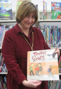 Laurie Collins holds the book that inspired the community service project in Newbury.