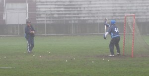 Triton coach Donna Andersen works out goalie Carson True before the game with Newburyport.