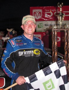 Eddie MacDonald with checkered flag in victory lane