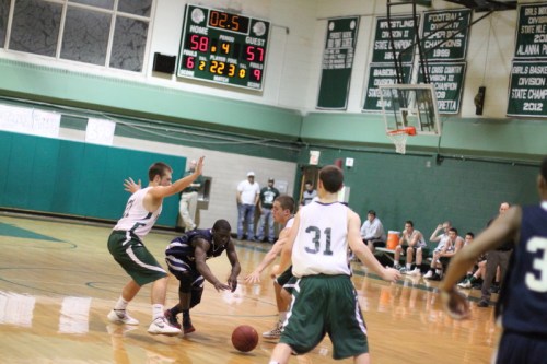 Gbah Dualu gets caught in a triple-team in the closing seconds of the game.