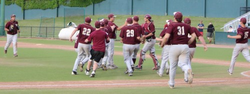 Whittier teammates gather around winning pitcher Andrew Wells