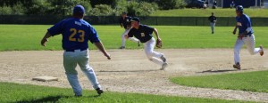 Third baseman Alex Ray chases a deflected ball as Drew Carter approaches third base.