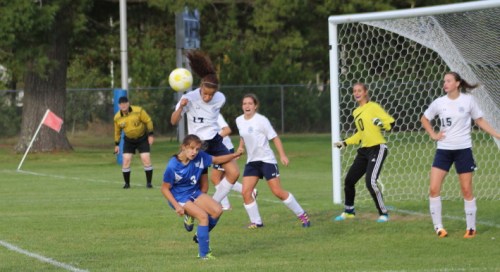 Orie Inirio heads out a Kennebunk corner kick over Sarah Thill