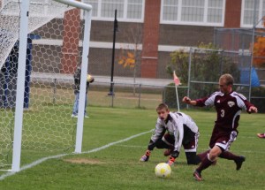 Ryder Bennell clears a ball away from in front of the Freeport net.