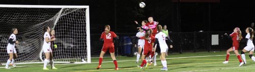 Haley Mignon (42) above the crowd looking to head in a corner kick.