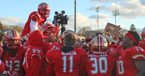 Everett players celebrate with the D1 Super Bowl trophy